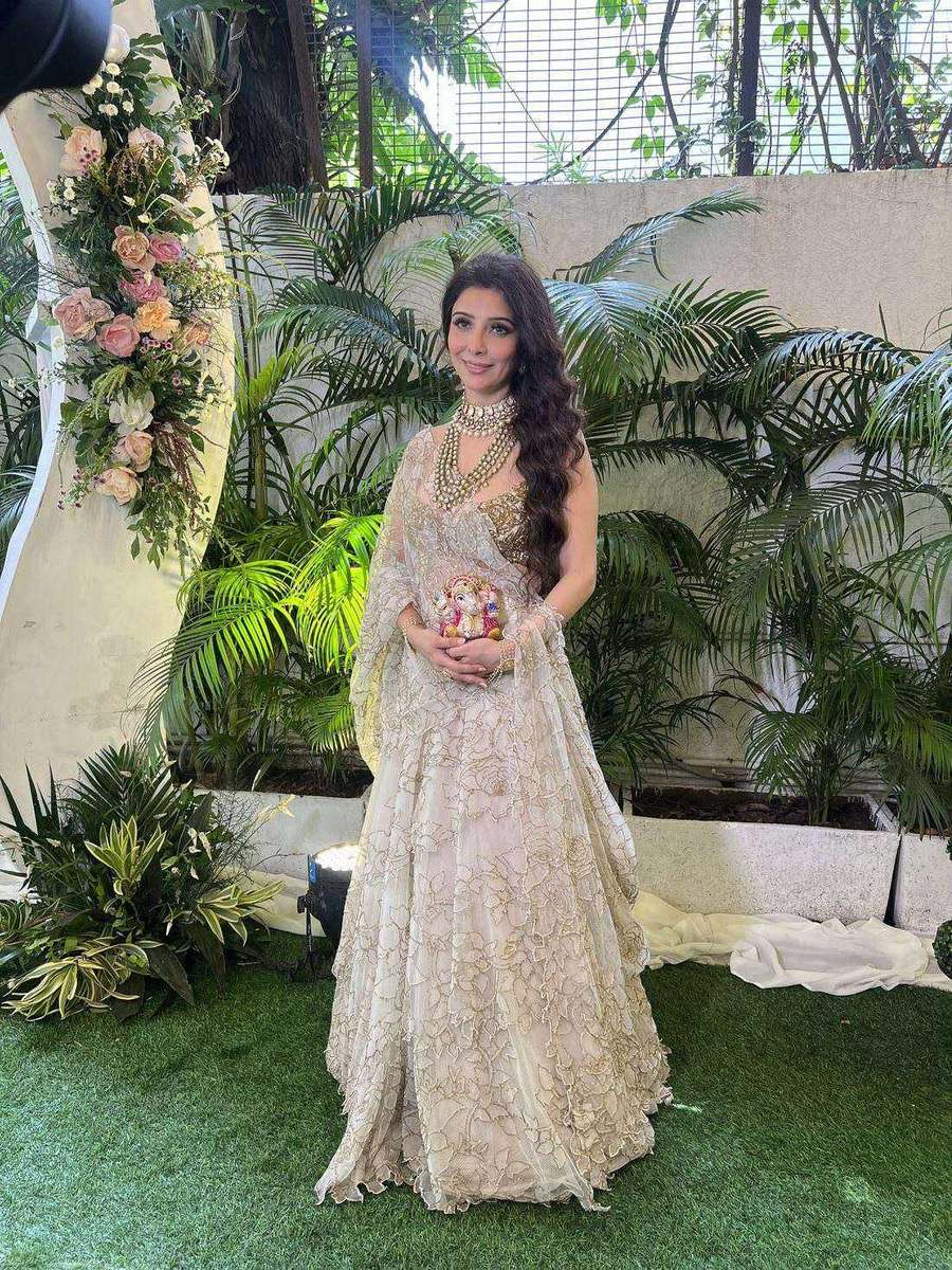 Dr. Jai Madaan, styled by Tanya Jain in an ivory embroidered lehenga in front of a floral arch