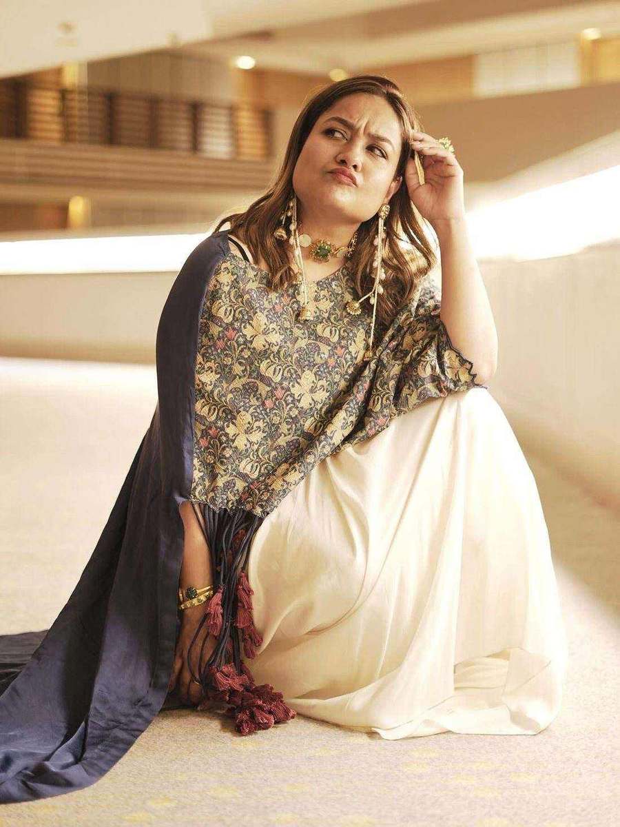 A styling client of Tanya Jain in the same look, seated with one hand raised to the hair