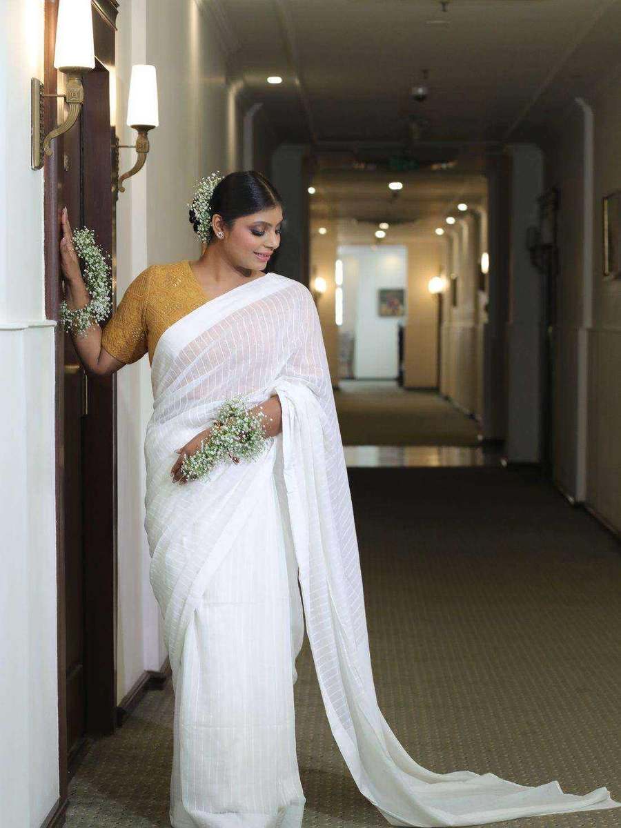 Tanya Jain in a white striped saree with a mustard blouse, photographed in a hotel corridor